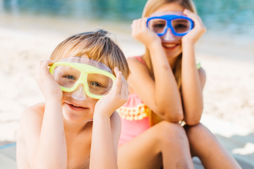 Enfants portant des lunettes de natation avec des etiquettes impermeables au bord de la piscine